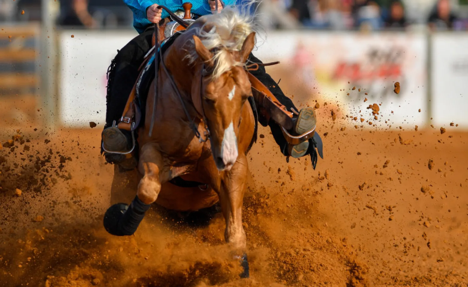 Horse and rider running through dirt